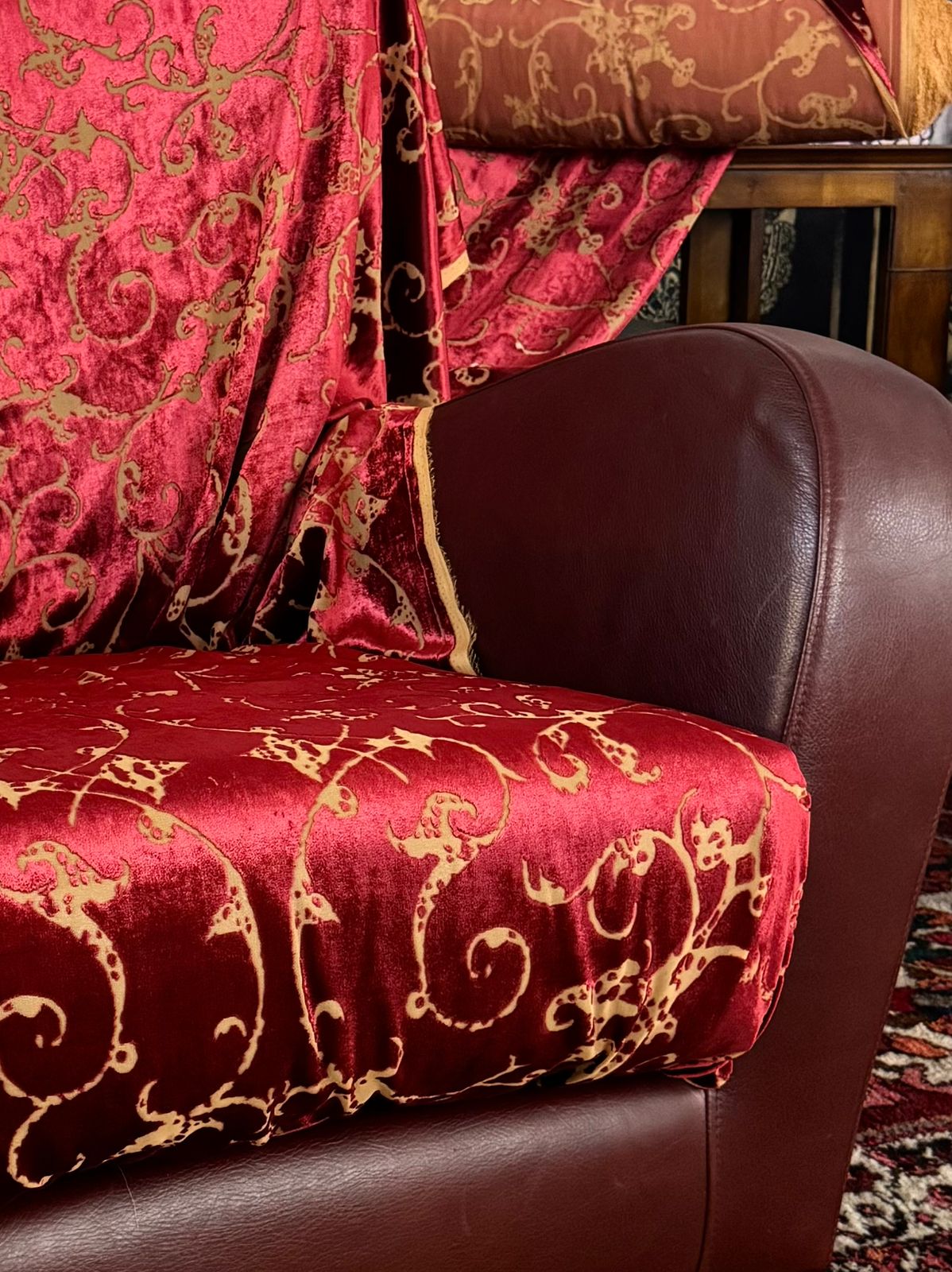 Red Italian velvet with gold floral pattern draped over an armchair in Factory BCN studio environment.