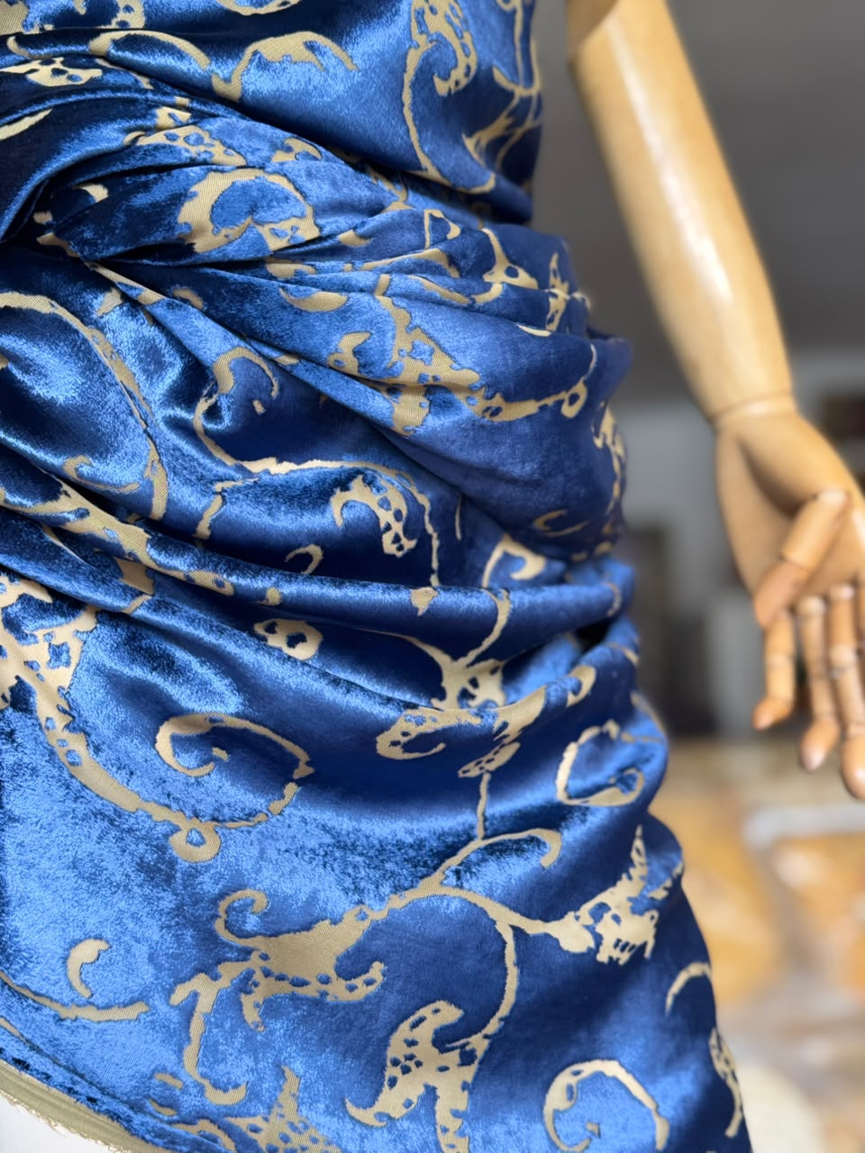 Blue Italian velvet with gold pattern draped on a mannequin inside Factory BCN studio.