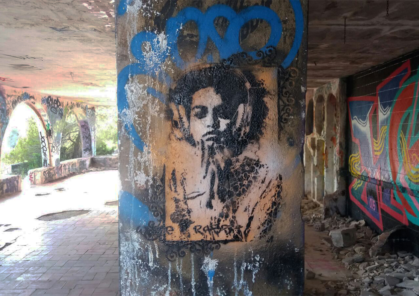 Black and white portrait street art by White Rabbit painted on a concrete column in Ibiza