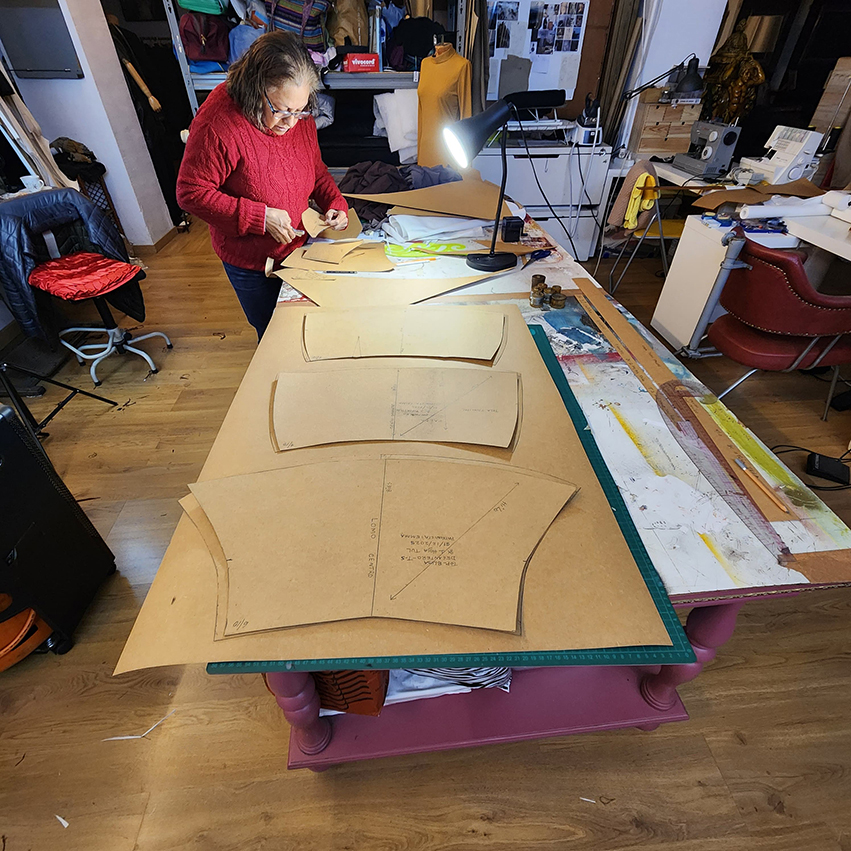 Fashion designer drafting paper patterns on a cutting table at Factory Atelier Barcelona