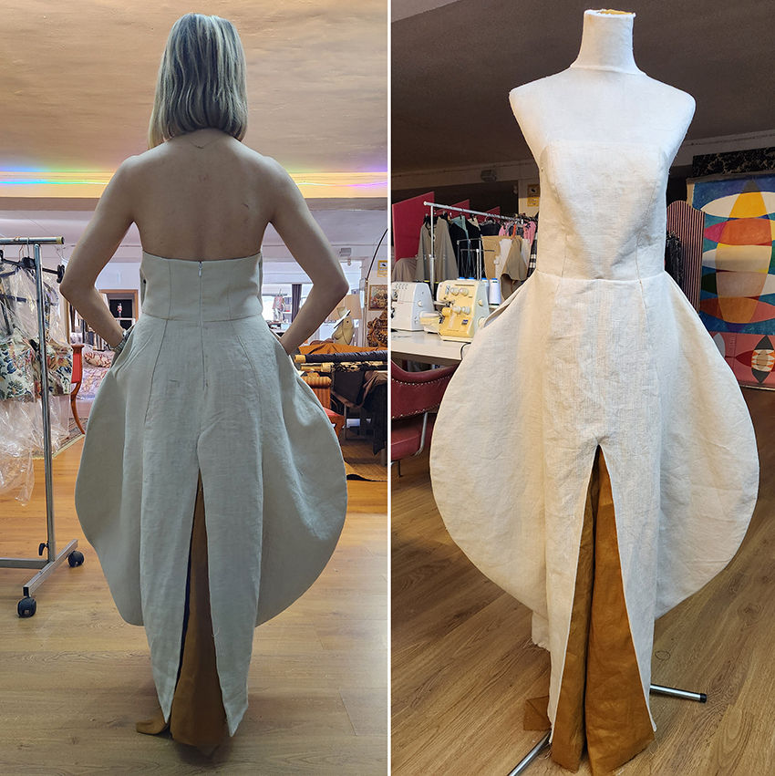 Front and back view of a cream sculptural dress prototype on mannequins in fashion atelier